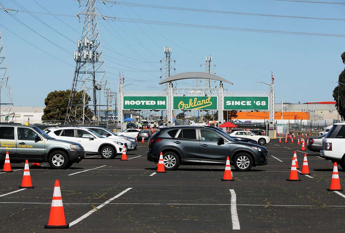 Vehicles wait in line in observation lanes at the Oakland Coliseum vaccination site on Thursday, March 25, 2021, in Oakland, Calif. The Coliseum vaccination site is only scheduled to be open for eight weeks, which means it will close in three weeks unless a deal is reached with local officials.