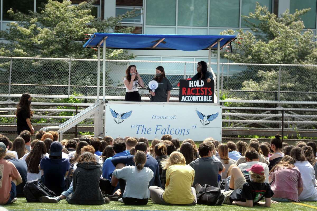 Fairfield Ludlowe High School students listen to some of their classmate speak during an organized walk out in Fairfield, Conn. May 24, 2021. Students at Ludlowe and across town at Fairfield Warde High School held walk outs Monday morning to protest recent racist incidents.