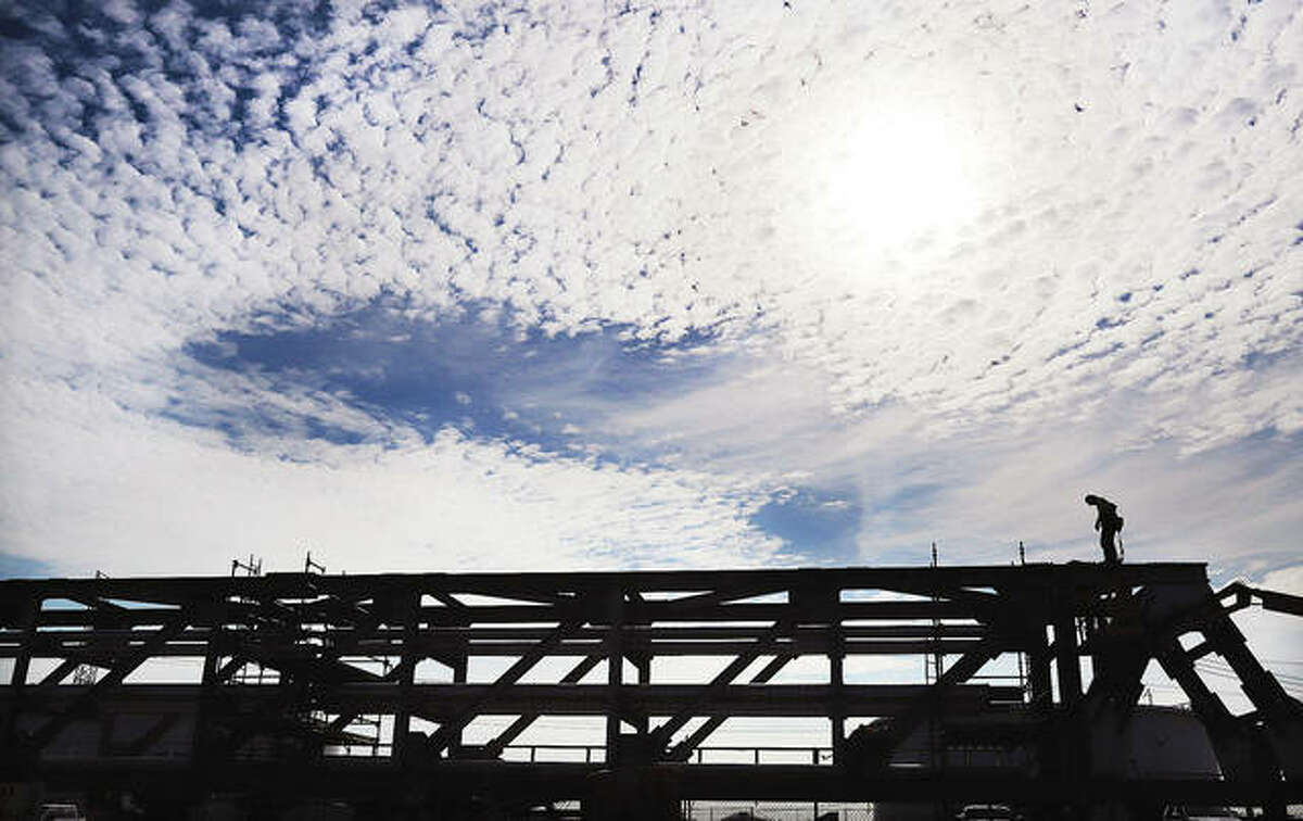 An employee of Federal Steel working on a long section of pipeline bridge is silhourtted by the Monday morning sun on property adjacent to the Hartford/Wood River Terminal in Hartford. The Illinois Department of Transportation has erected traffic warning signs to alert motorists to a complete closure of Illinois 3 from 12 a.m. Friday, June 4, through 5 a.m. Monday, June 7.