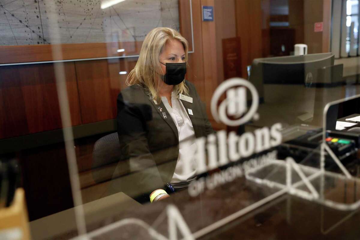 Nora Johnson works at the front desk as Hilton Union Square reopens for business in San Francisco, Calif., on Monday, May 24, 2021.