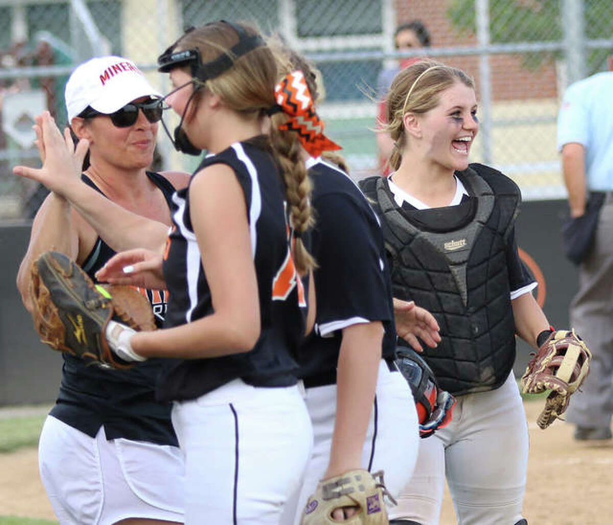 Gillespie catcher Hannah Barrett (right) waits for pitcher Sydney Bires to join the celebration while Miners coach Michelle Smith welcomes players off the field after a 4-1 win over Southwestern on Monday in Gillespie.