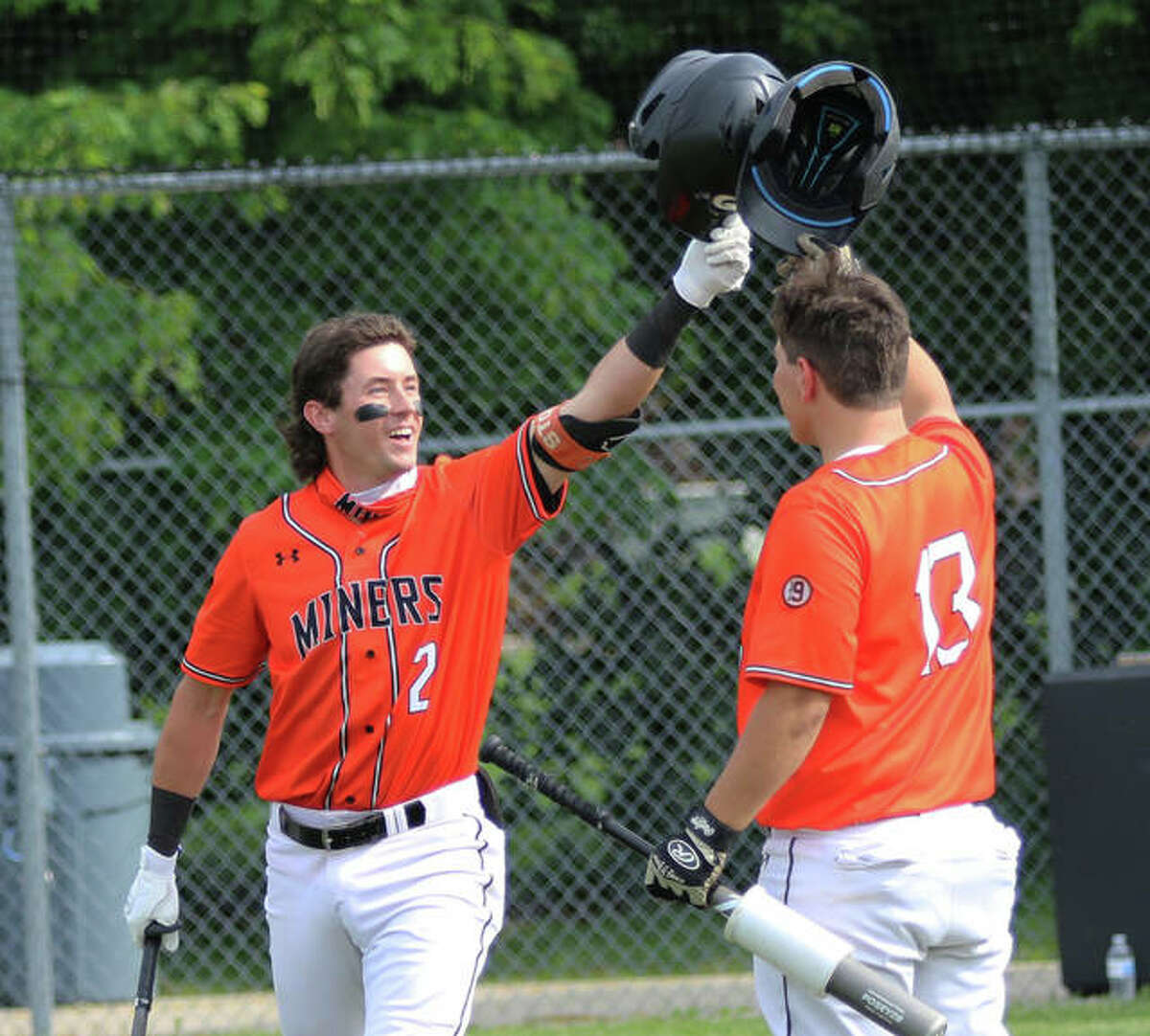 Gillespie’s Cameron Hailstone (left) gets a congratulatory helmet tap from teammate Gavin Griffith after Hailstone’s first of two home runs in the Miners’ win over Southwestern on Monday in Gillespie.