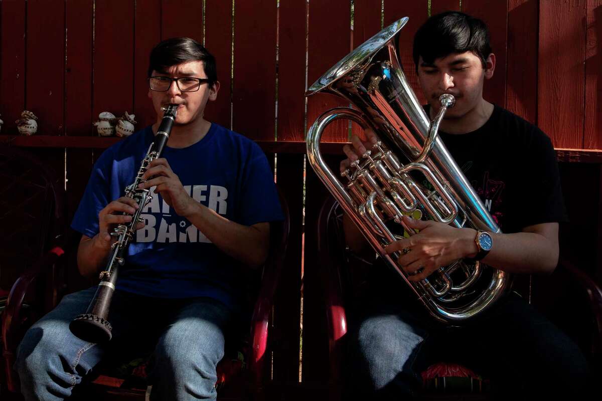 Fabien and Damien Chavez play the clarinet and euphonium, respectively, in their backyard. The twins are graduating from Lanier High School as valedictorian and salutatorian after making all-region and all area band. Fabien also made all-state band.
