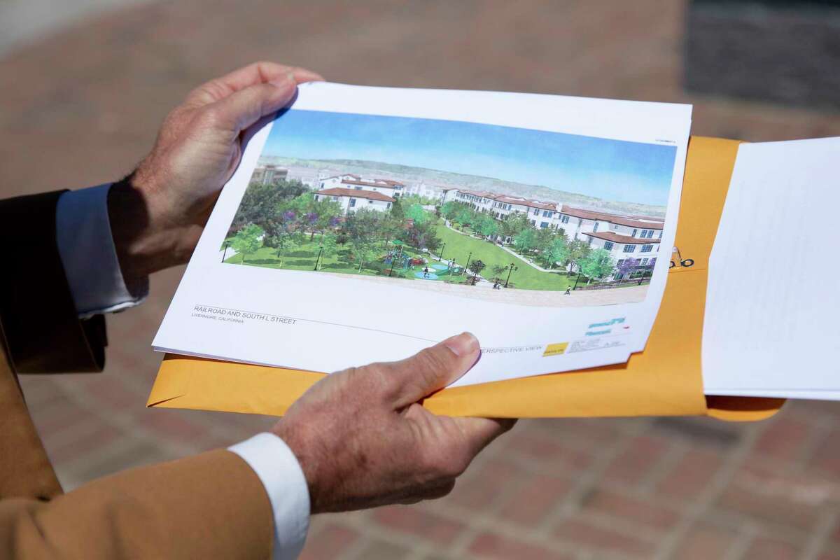 John Marchand, a former mayor of Livermore, holds a print of the new affordable housing project that is suppose to be built in conjunction with Stockmen's Park in Livermore, Calif. on Wednesday, May 19, 2021.