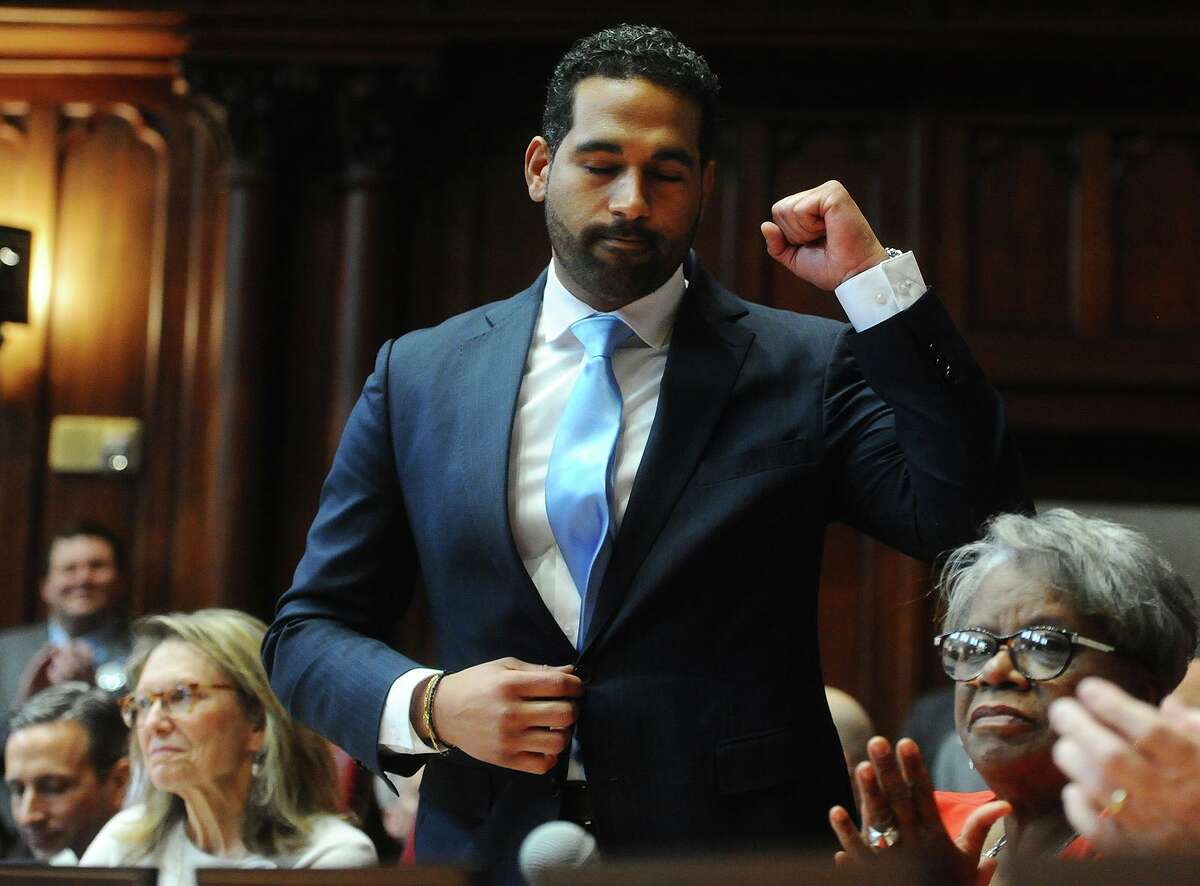 State Senator Dennis Bradley, D-Bridgeport, pumps a fist after being introduced during the opening session of the senate at the Capitol in Hartford, Conn. on Wednesday, January 9, 2019.