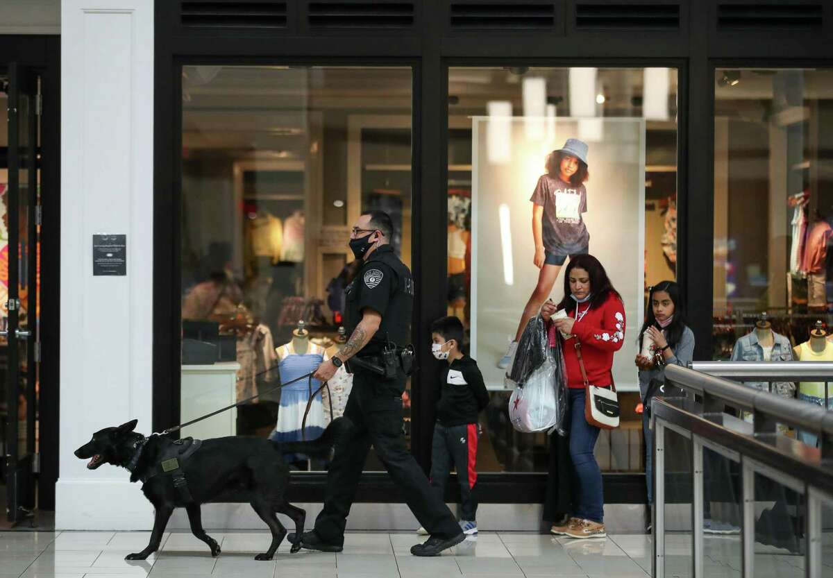 Security officer Brandon Brinkman and his K-9 partner Maki make their rounds inside Deerbrook Mall on Saturday, April 17, 2021, in Humble, Texas. Maki is a firearm-sniffing dog, he alerts Brinkman if a visitor has any gunpowder residue on their person. The measure is an effort to stave off shootings and make people feel safe coming to shop.