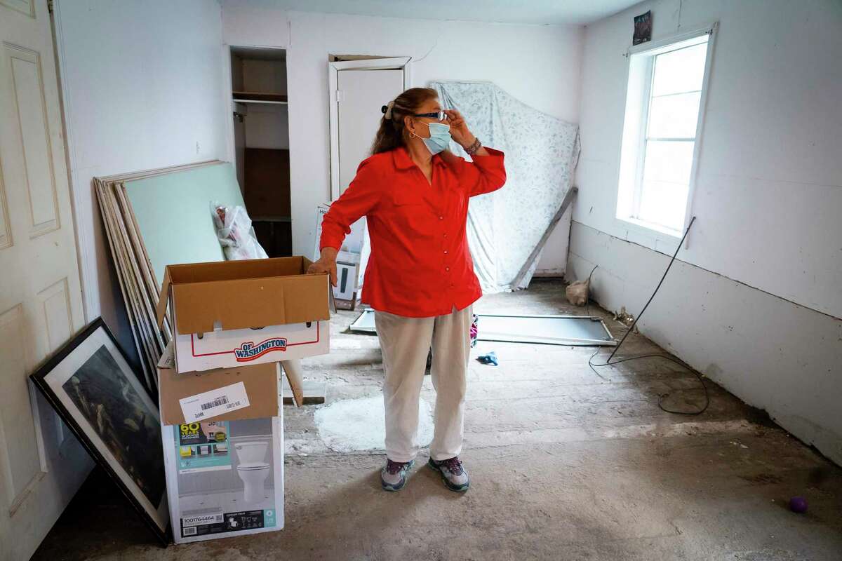 Valeria Tamez walks through her Harvey-damaged home, Friday, Nov. 13, 2020, in southeast Houston. The foundation of the house is severely damaged and cracks can be seen on the floor, walls and the ceiling. Tamez was recently notified by the city that her application for housing relief would have to move from the city's program to one being run by the state's General Land Office.