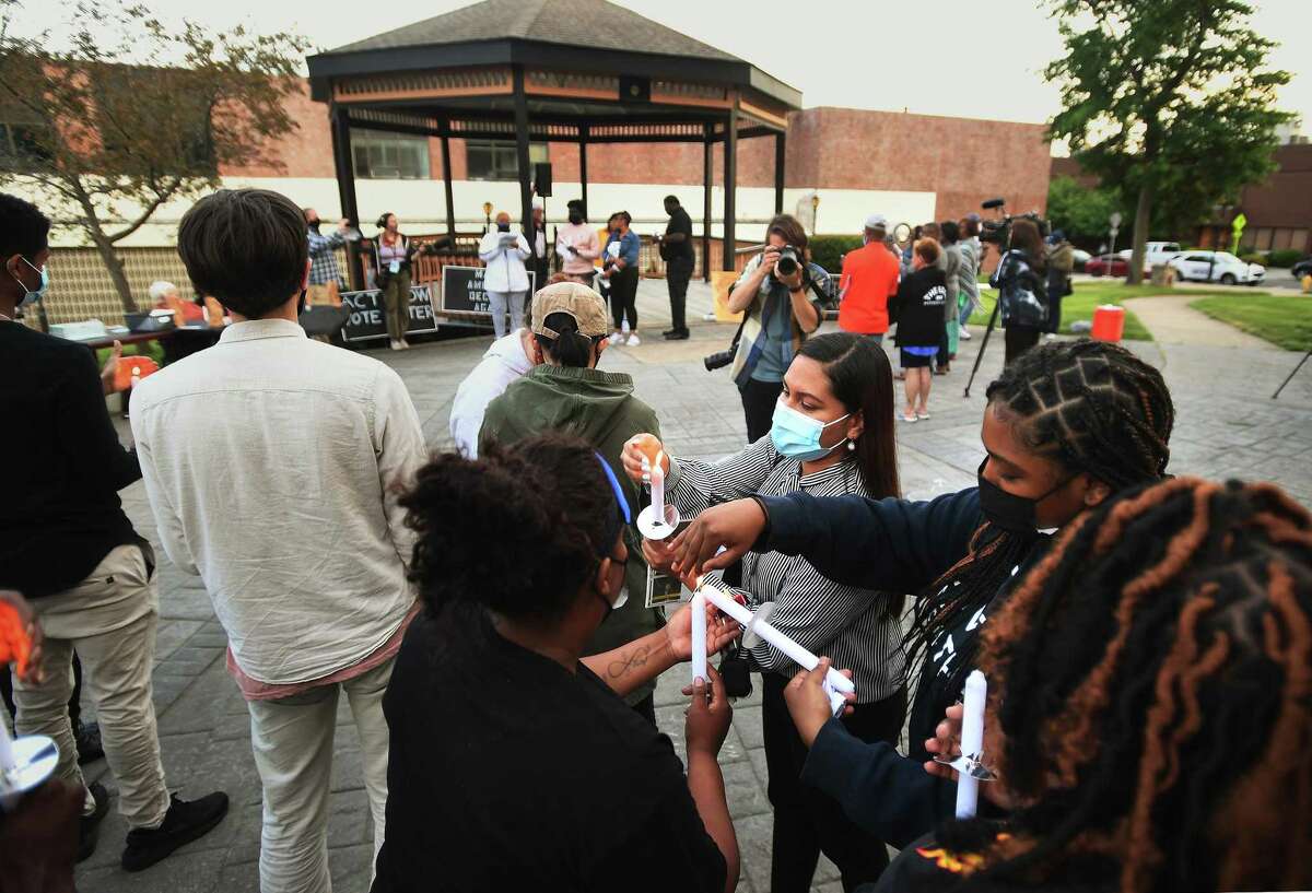 Candles are lit during an NAACP vigil commemorating the one year anniversary of George Floyd's death on the Green in Derby, Conn. on Tuesday, May 25, 2021.