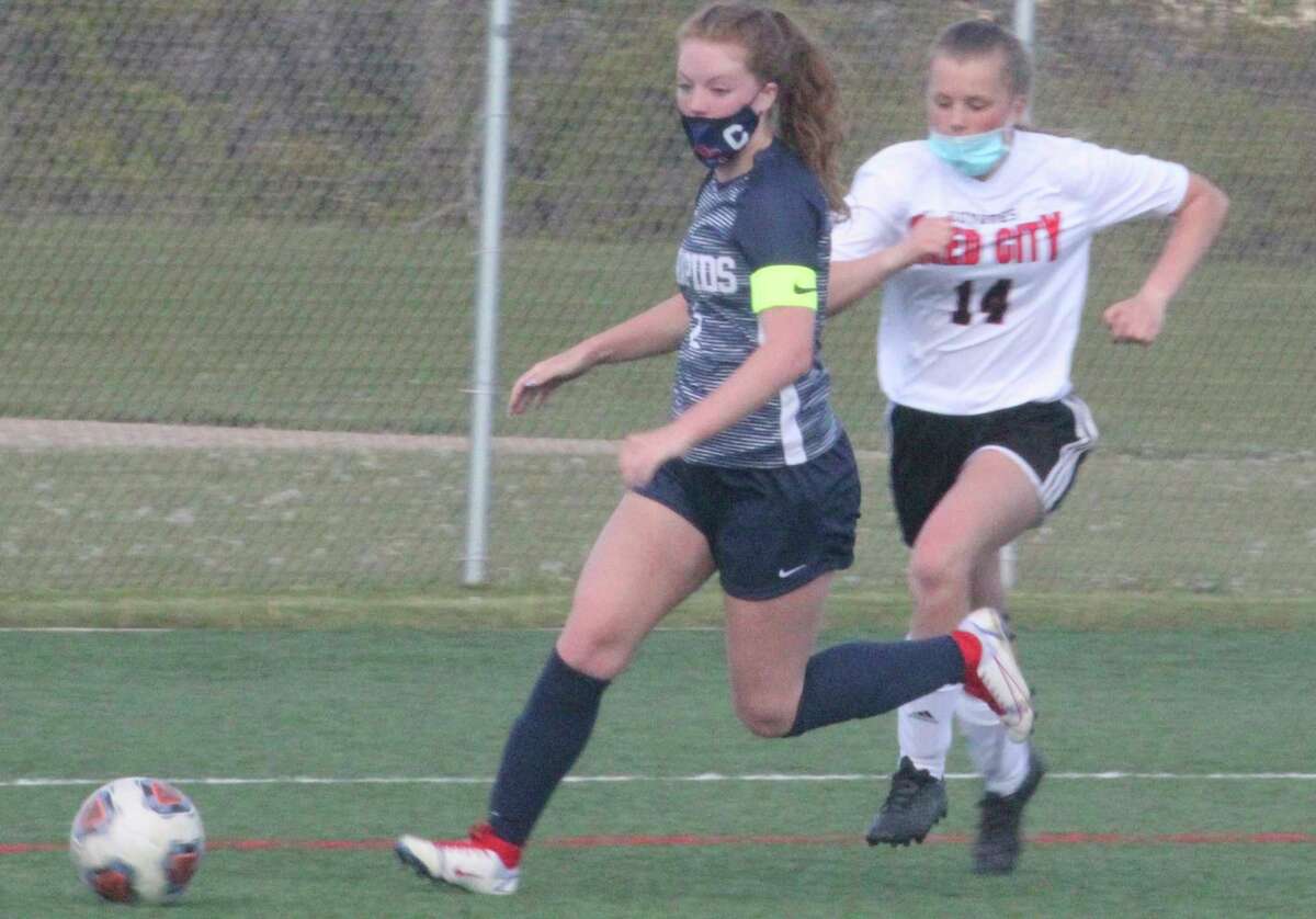 Reed City soccer's Aleeya Stein (14) pursues Big Rapids' Ariana Costie in action earlier this season. (Herald Review file photo)