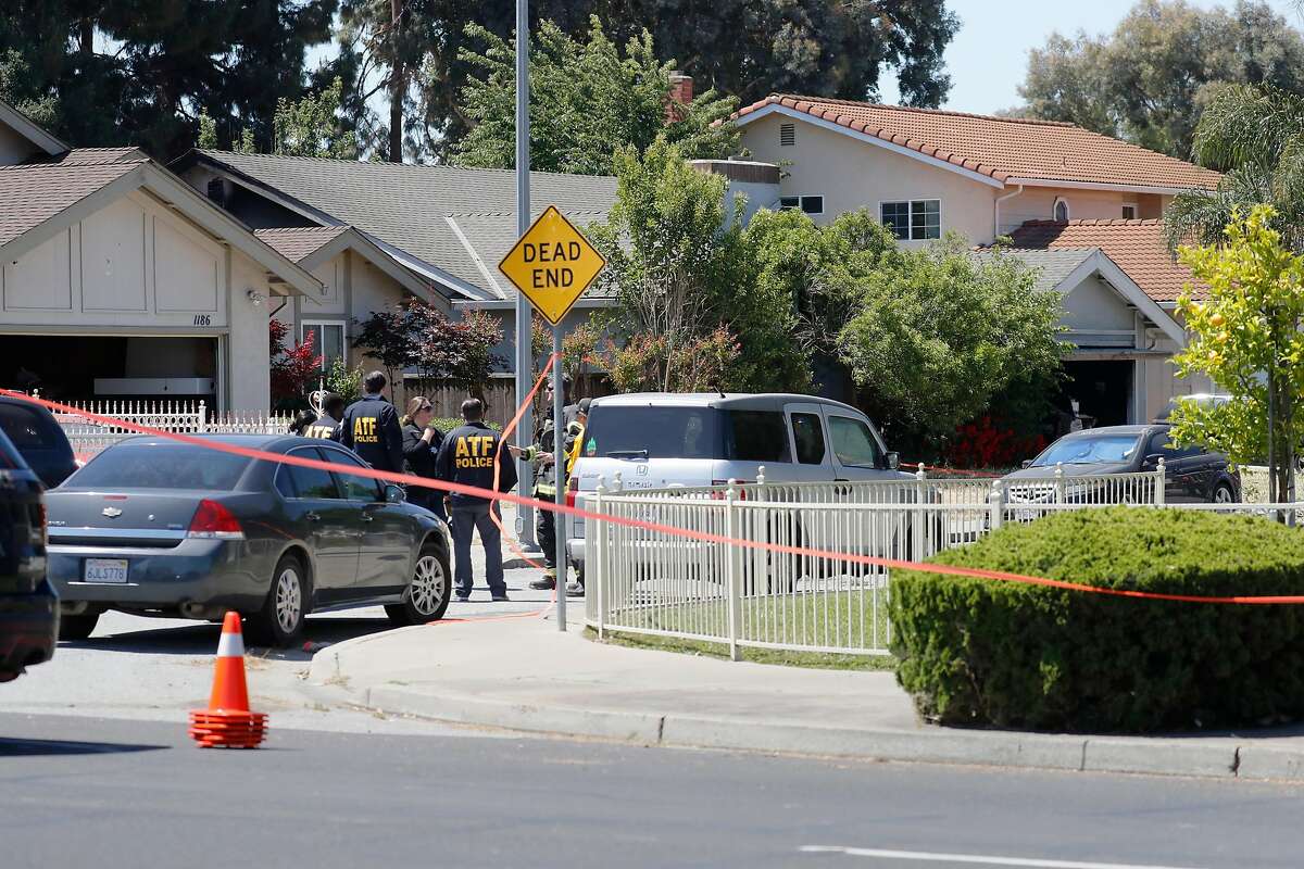 Investigators gather at the fire scene of a home on Angmar Court related to the VTA service yard mass shooting that took place around the same time as the fire Wednesday, May 26, 2021, in San Jose, Calif. The house in question, at center, has a gray roof.