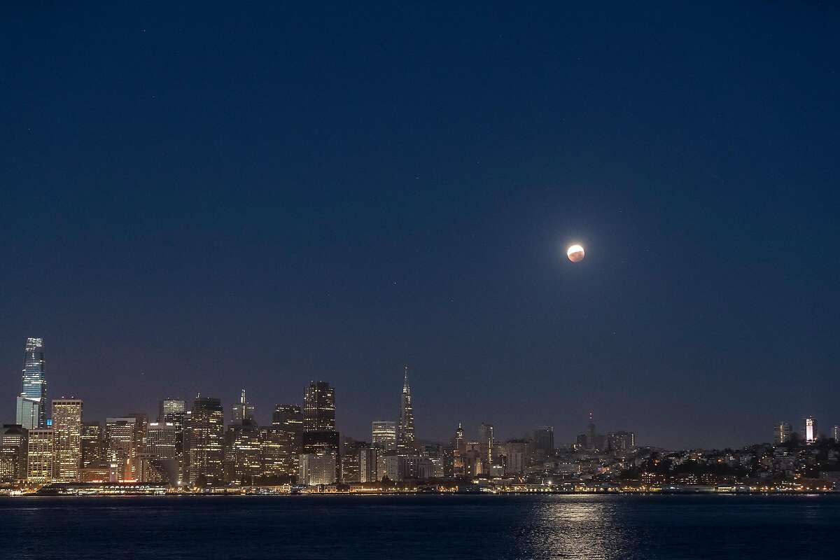 The partially-eclipsed Super Flower Blood Moon is visible above the city skyline in San Francisco, Calif., on Wednesday, May 26, 2021. The moon was in full eclipse for 14 minutes, with part or all of the moon eclipsed by the Earth’s shadow for several hours.