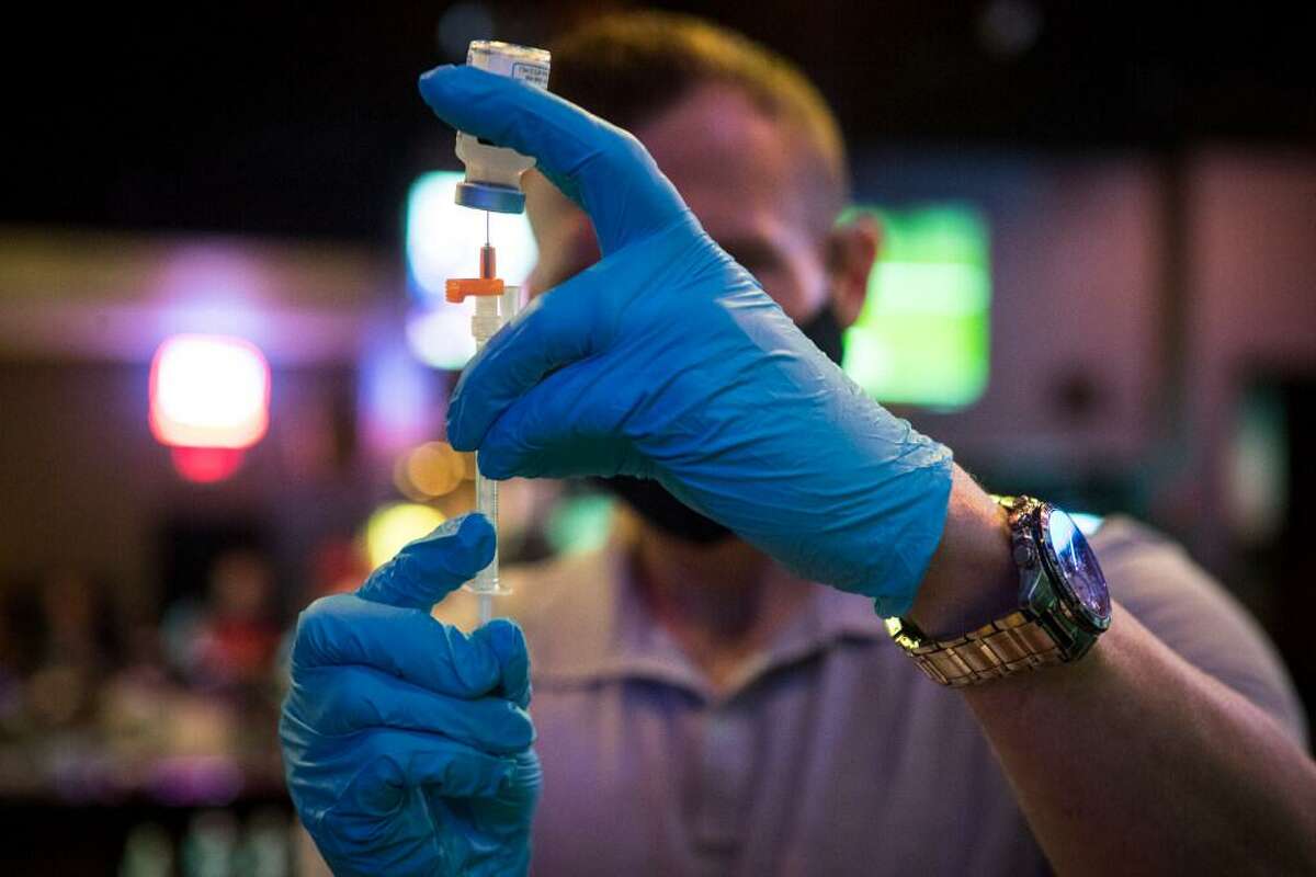 Ruston Tayor fills a syringe with a dose of Moderna COVID-19 vaccine during a pop-up vaccination clinic at BUDDY'S Houston in Montrose on Thursday, April 29, 2021 in Houston. BUDDY'S teamed up with Wellness Bar by Legacy to offer vaccines by appointment.
