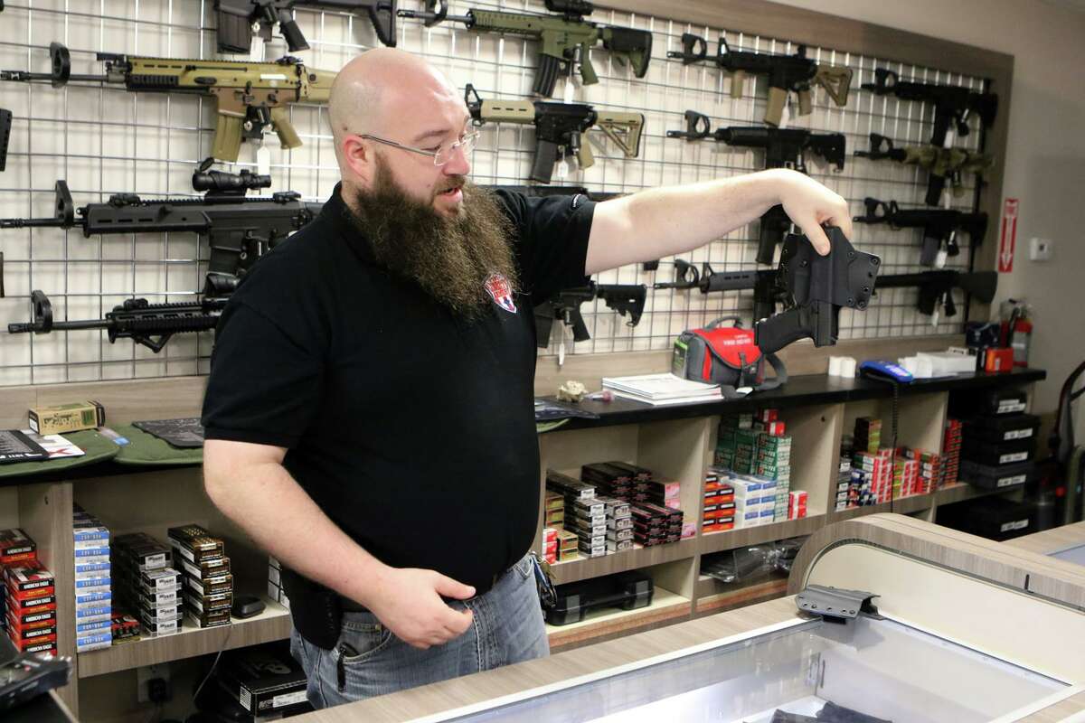 Owner Joseph Beck shows a Bravo Concealment kydex gun holster that can be used for open carry of a firearm at The Liberty Armory in Bellaire, Texas on Thursday, March 19, 2015.