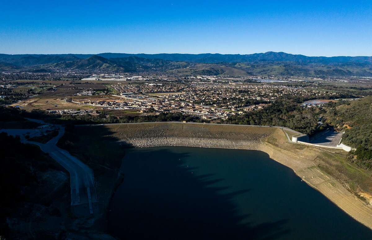 An aerial view of the dam and homes below it at Anderson Reservoir in February 2020. Anderson Lake is Valley Water’s largest reservoir and is now drained for earthquake repairs.
