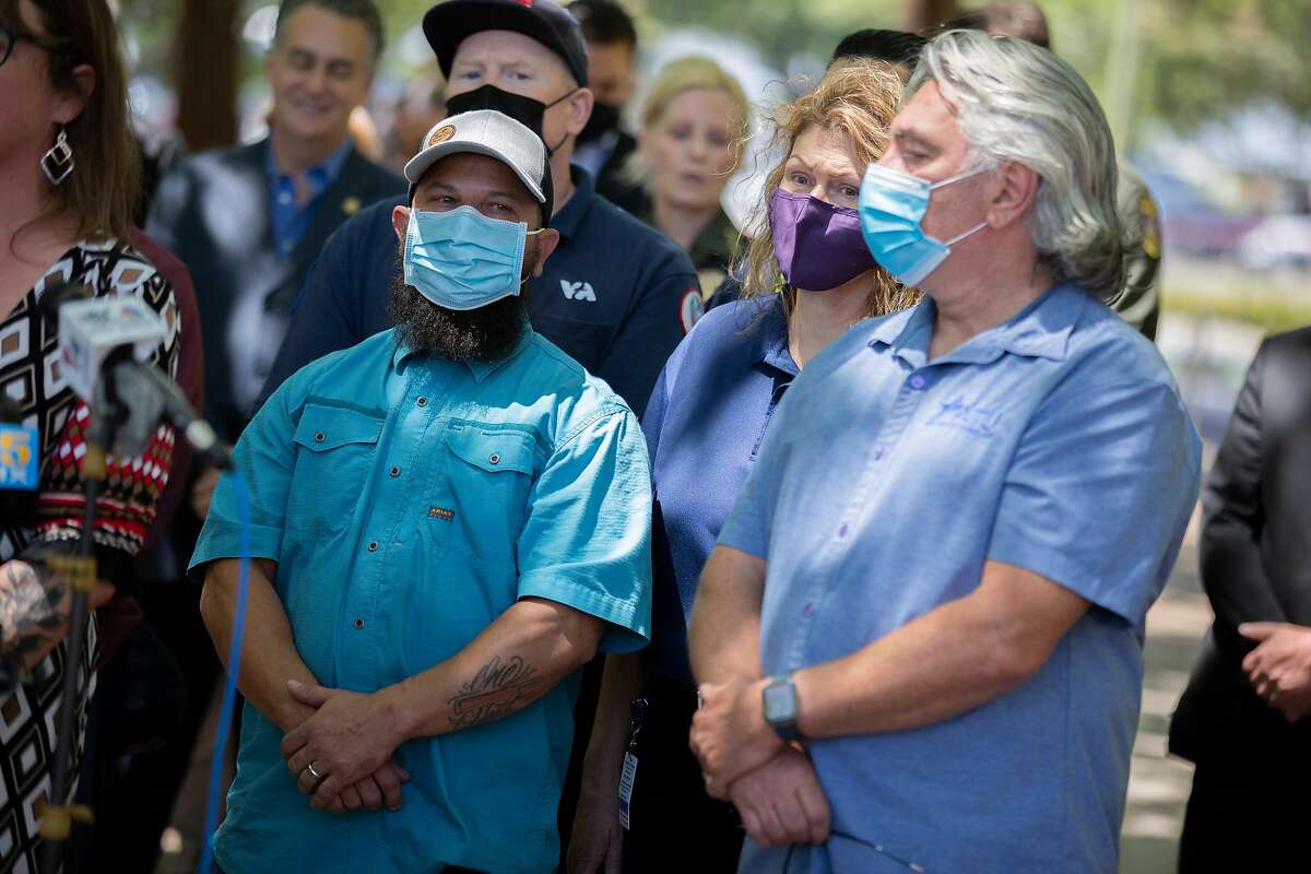 Valley Transportation Authority employees listen to a news conference after a mass shooting at a nearby VTA rail yard.