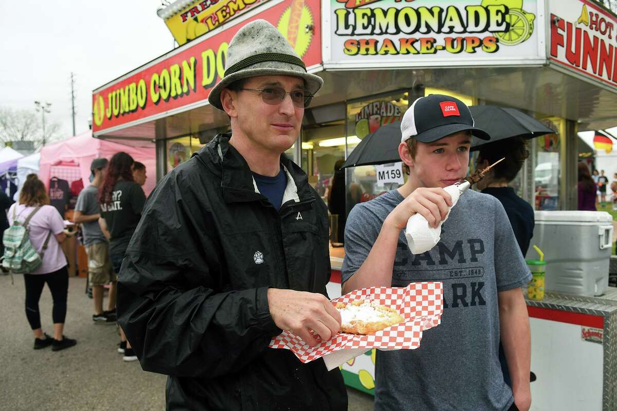 Martin Mohr, left, of Houston, and his son Mike, 15, a sophomore at Houston Memorial High School, enjoy a snack at the Tomball German Heritage Festival at the Tomball Depot on March 30, 2019.