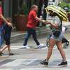 A pedestrian shields herself from rain with an umbrella in downtown San Antonio on Monday, May 24, 2021. Those diligent enough to keep an umbrellas with them were better prepared for the isolated showers that popped up on Monday.