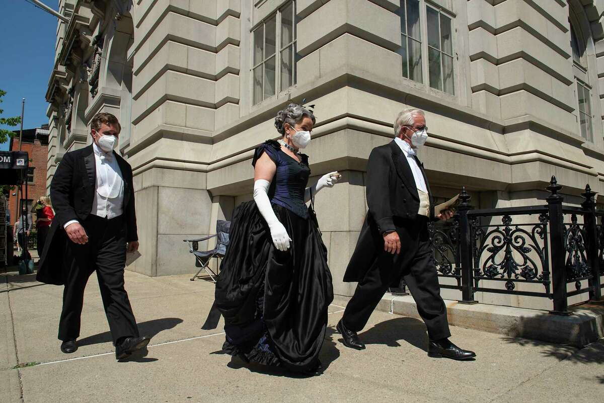 Actors and extras are seen walking around the corner of the Troy Savings Bank Music Hall during filming of "The Gilded Age" on Thursday, May 27, 2021, in Troy, N.Y. 