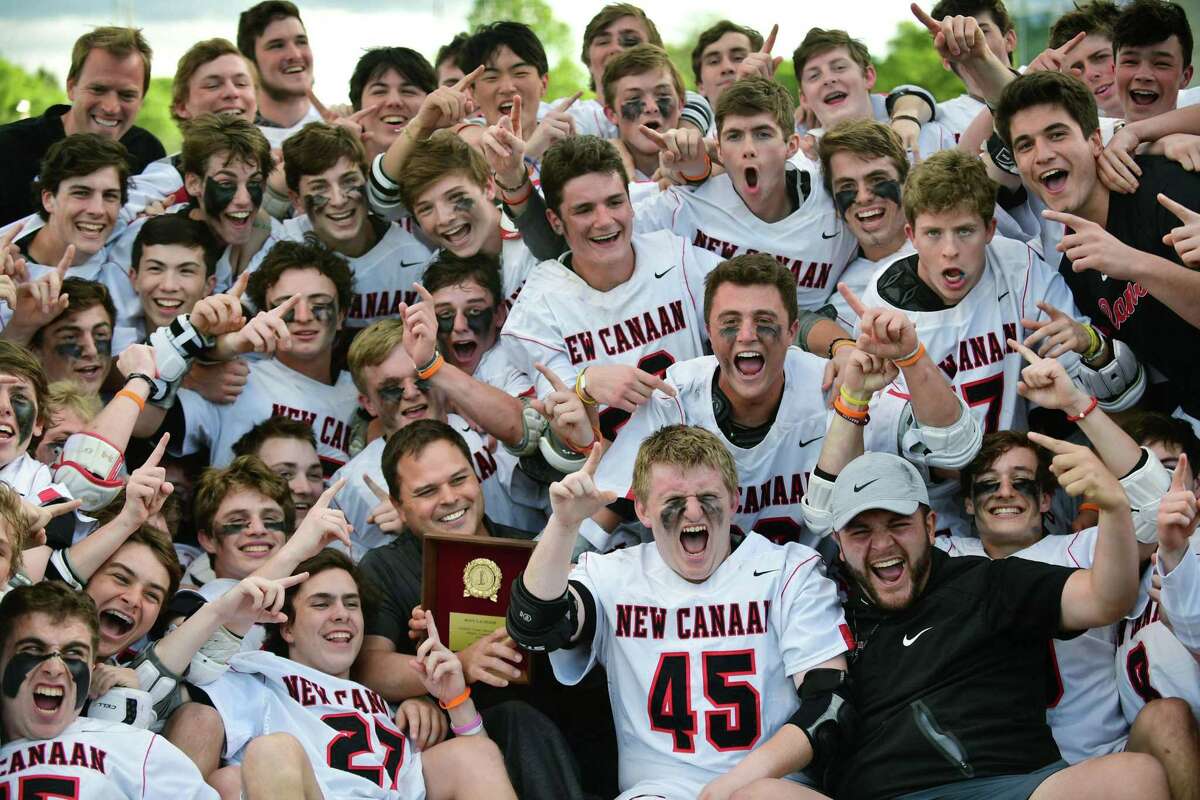 The New Canaan High School Rams celebrate withtheir coach Chip Buzzeo after beating the Wilton High School Warriors in their FCIAC boys lacrosse championship Thursday, May 23, at Brien McMahon High School in Norwalk, Conn.