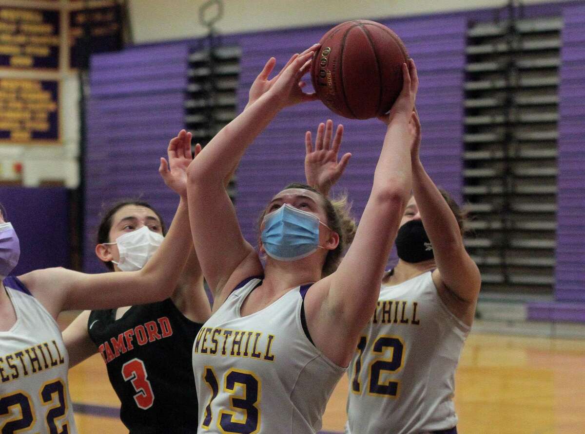 Westhill's Peyton Hackett (13) grabs a rebound during girls basketball action against Stamford in Stamford, Conn., on Saturday Feb. 20, 2021.