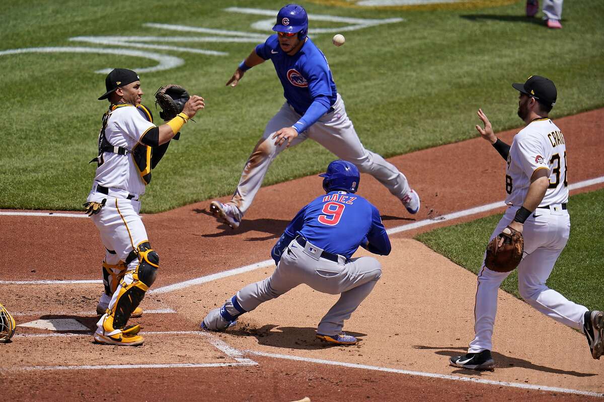 Will Craig tosses the ball to catcher Michael Perez after chasing Chicago batter Javier Baez to the plate as Willson Contreras prepares to slide. Baez reversed course and wound up on second after an errant throw.