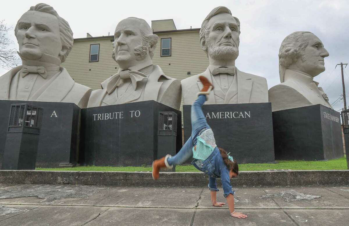Jayde Scott does a cartwheel in front of artist David Adickes'