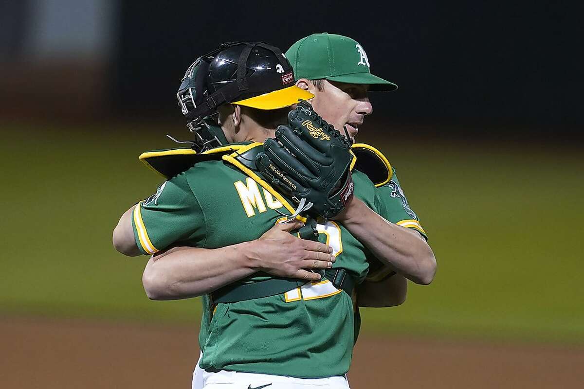 Oakland Athletics catcher Sean Murphy, foreground, celebrates with pitcher Chris Bassitt after the Athletics defeated the Los Angeles Angels in a baseball game in Oakland, Calif., Thursday, May 27, 2021. (AP Photo/Jeff Chiu)