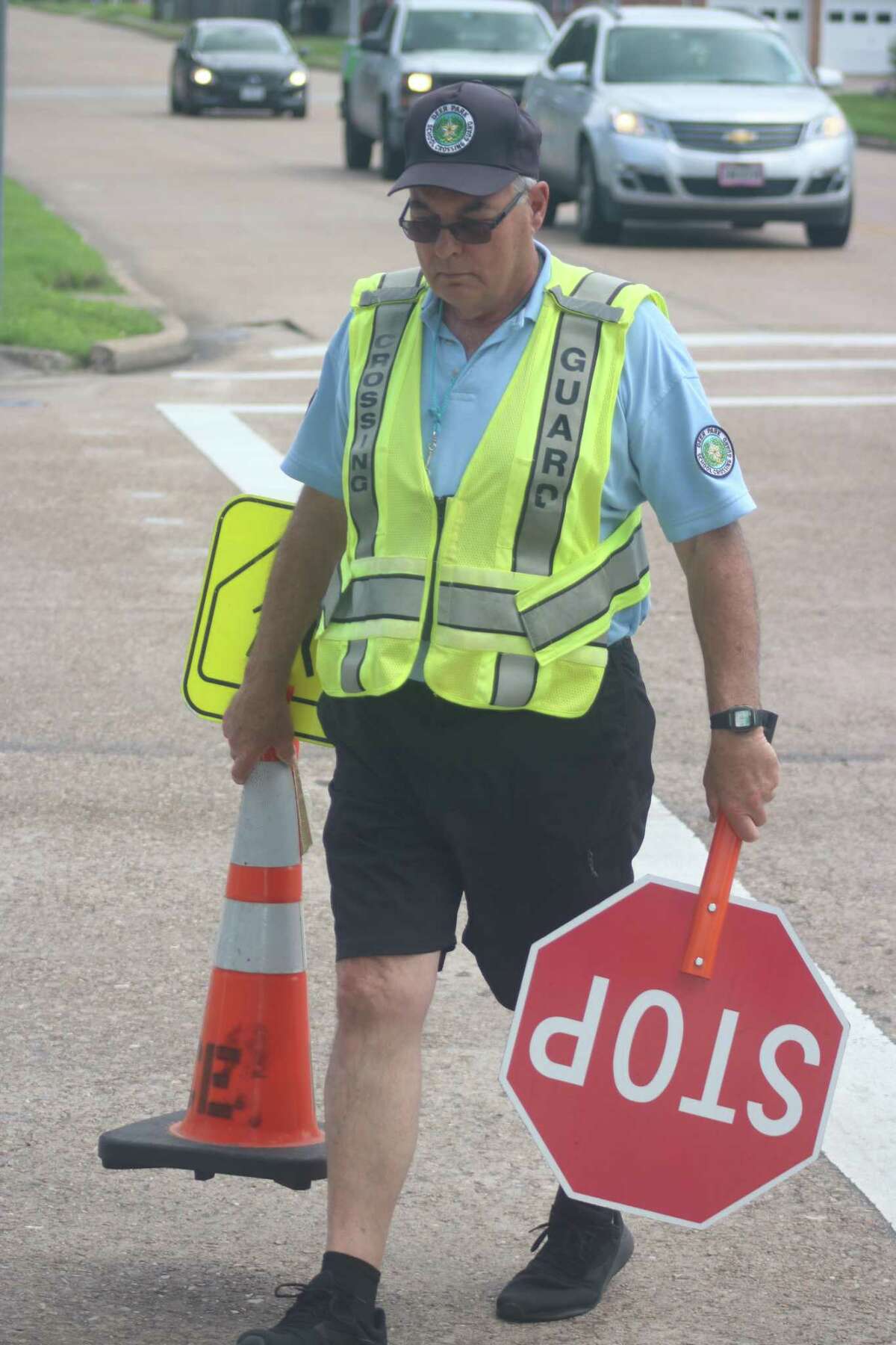 Carrying his necessary equipment, school crossing guard Mike Cheney leaves his Deer Park intersection for the final time of the 2020-21 school year.