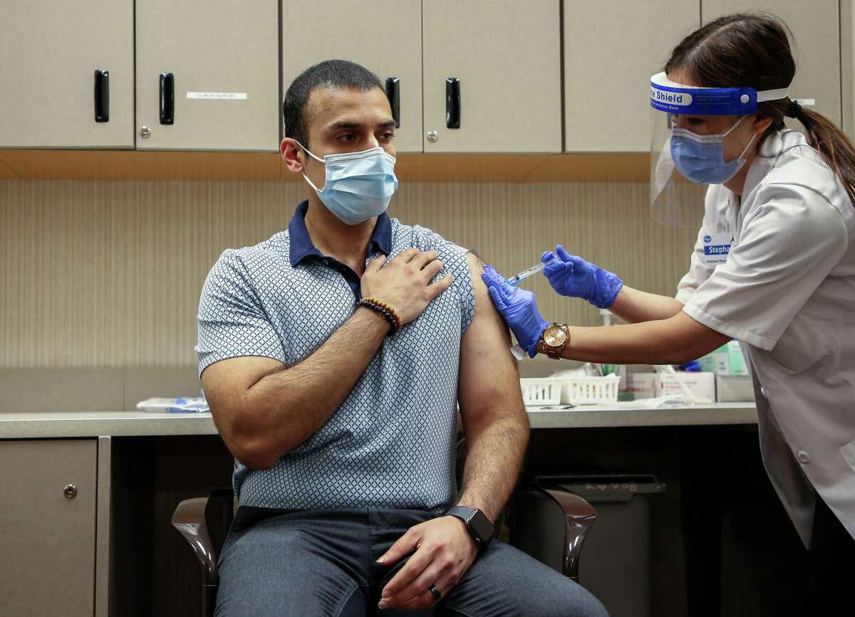 Pharmacist Stephanie Phan, right, administers a dose of COVID-19 Moderna vaccine to Nabeel Sattar, pharmacy manager, at the Kroger located at 1440 Studemont Street, on Wednesday, Jan. 6, 2021, in Houston. 