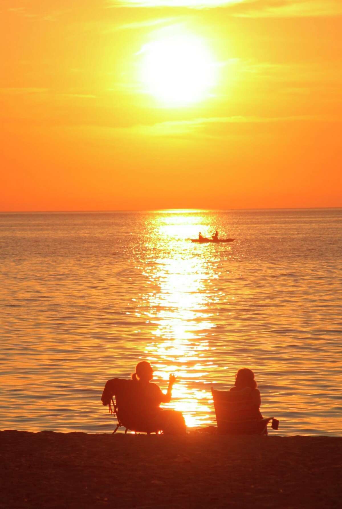 Taking in a sunset on the shores of Lake Michigan is a wonderful way to punctuate a summer night. (File photo)