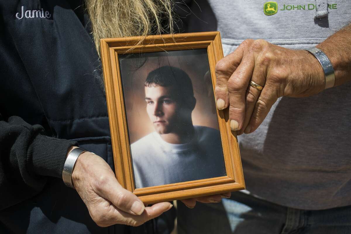 Jamie Zylman, left, and Randy Zylman, right, pose for a portrait Friday, May 28, 2021 with a photo of their late son, Army Cpl. Casey Zylman, who was killed in action May 25, 2007 while serving during Operation Iraqi Freedom. (Katy Kildee/kkildee@mdn.net)