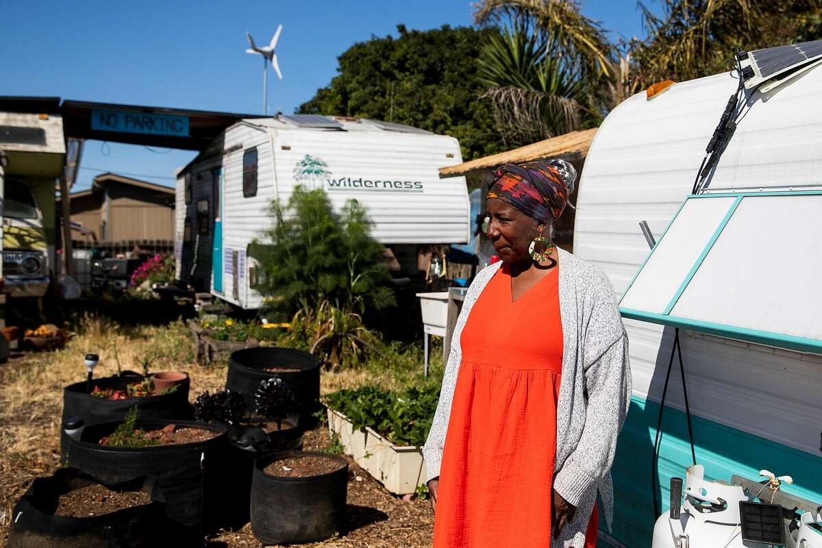 Sauda Garrett, the mother of Neighborship co-operative village founder Adam Garrett-Clark, stands outside of her RV in West Oakland.