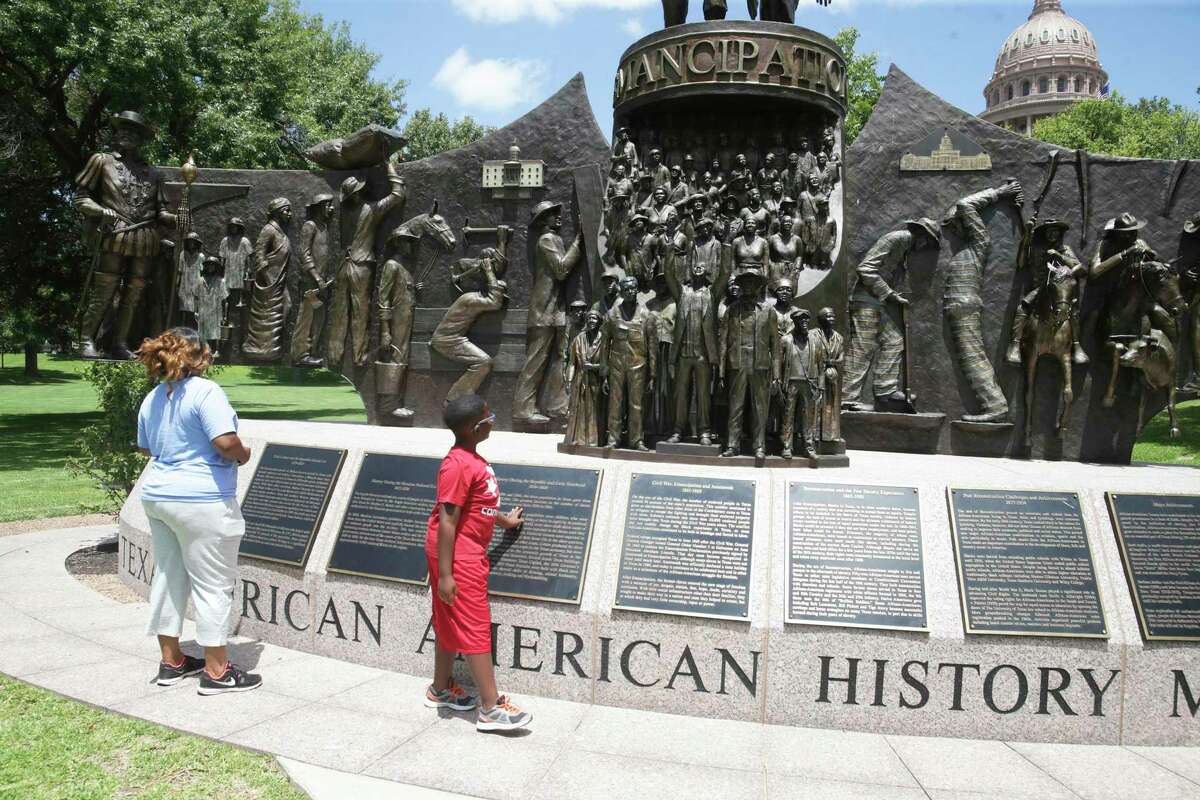 Troylandria Jackson and her nephew Jaxson Poole examine the Texas African American History monument on the south lawn of the Capitol on August 16, 2017.