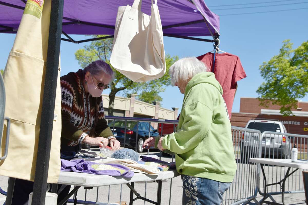 Market Manager Ramona DeGeorgio-Venegas helps a patron with a purchase of market merchandise for sale at the entrance area on Saturday, May 29.