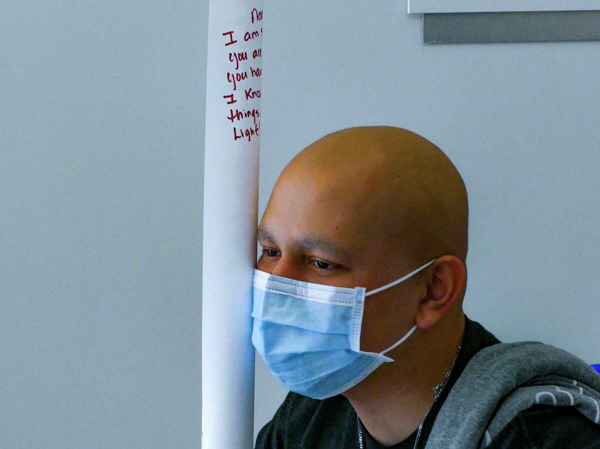 Noah Adams holds a rolled poster containing messages from staff at University Hospital on May 14. He rang a bell, a traditional signal that he is now cancer free.
