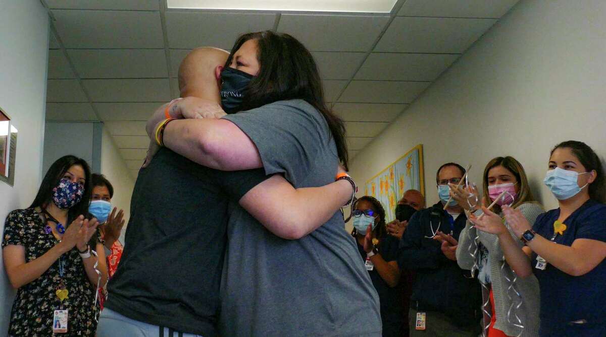 Noah Adams' mother, Debi Harper, embraces him after his end-of-therapy visit at University Hospital on May 14, where he rang a bell, a tradition for cancer patients to signify they are now cancer free.