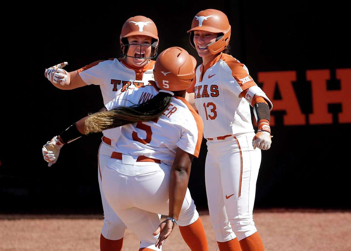 Taylor Ellsworth and Shannon Rhodes (13) celebrate a home run by Jordyn Whitaker, a freshman, in the sixth on Saturday. Whitaker’s shot broke a 1-1 tie and preceded another Texas homer.