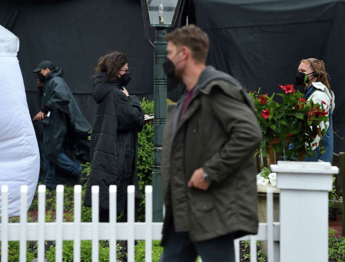 Actors Bonnie Bedelia (left center) and Justin Hartley (right center) walks between locations on the Griswold Inn property during the filming of scenes for the movie, The Noel Diary, in Essex on May 29, 2021.