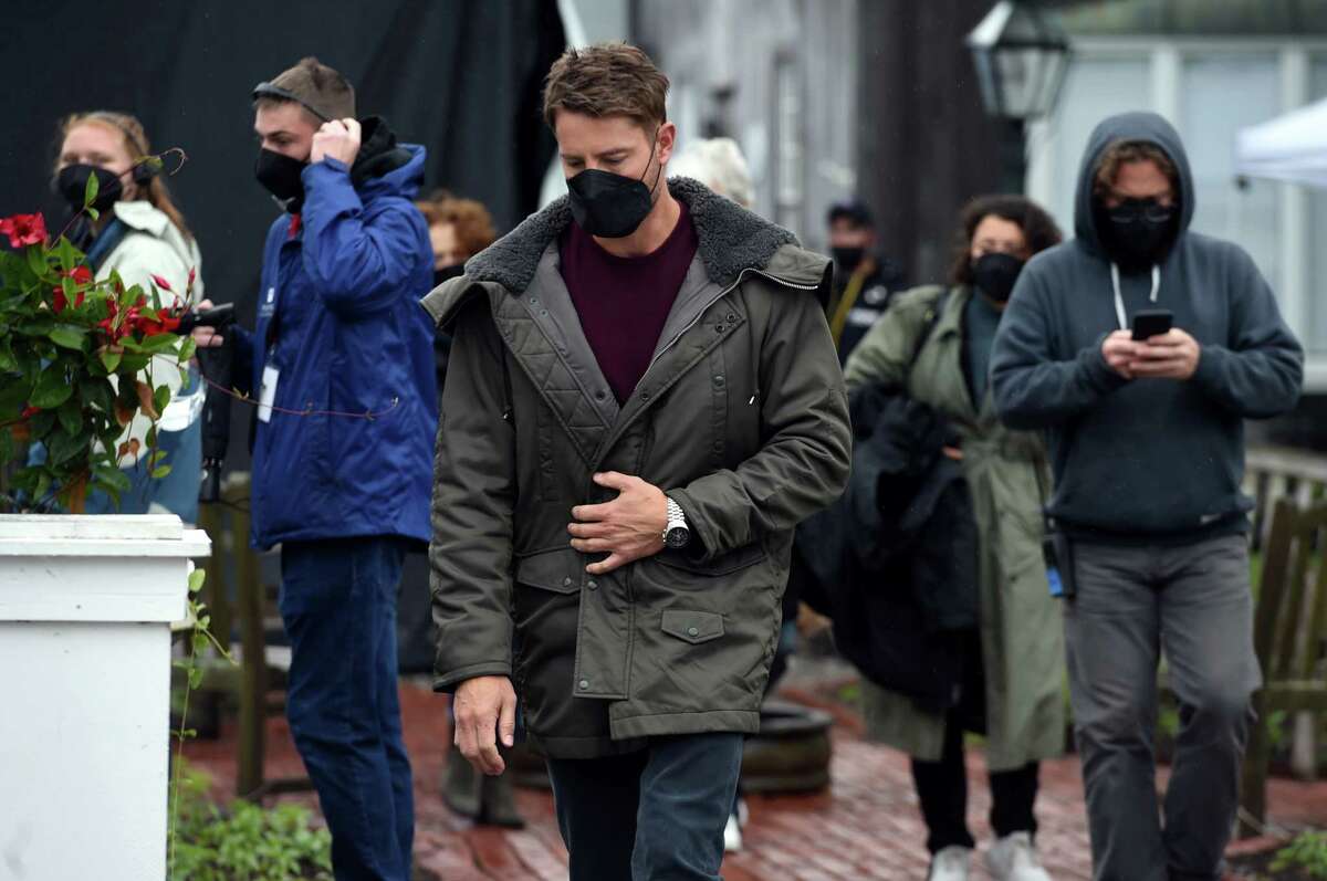 Actor Justin Hartley (center) walks to the Griswold Inn Store for the filming of a scene for the movie, The Noel Diary, in Essex on May 29, 2021.