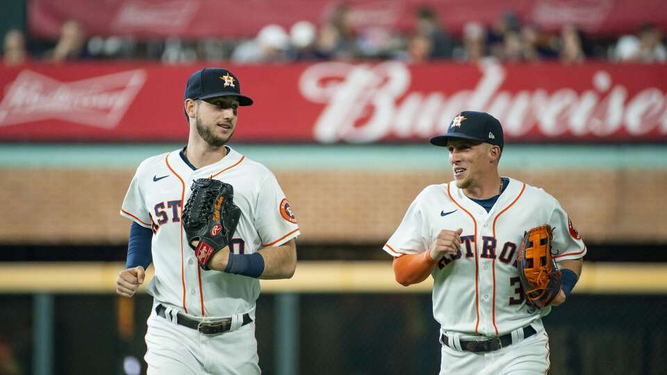 Houston Astros left fielder Kyle Tucker (30) and Houston Astros center fielder Myles Straw (3) run off the field at the end of the top of the third inning after Straw caught a fly out from San Diego Padres third baseman Manny Machado (13) during an MLB game between the Houston Astros and San Diego Padres on Saturday, May 29, 2021, at Minute Maid Park in Houston.
