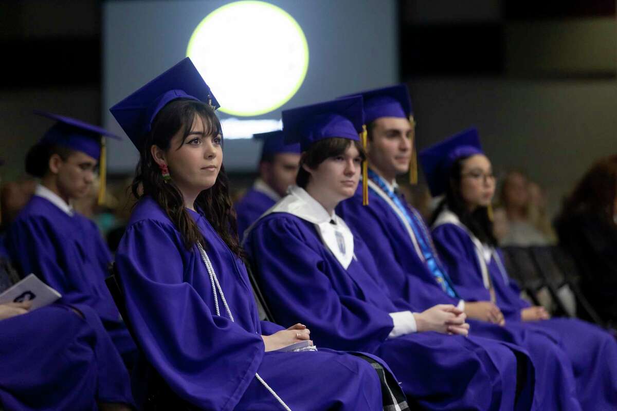 Cali Noack, left and other graduates watch as their Class president offers a welcome speech during Tomball Star Academy's graduation ceremony at the Magnolia Event Center, Thursday, May 27, 2021, in Magnolia.