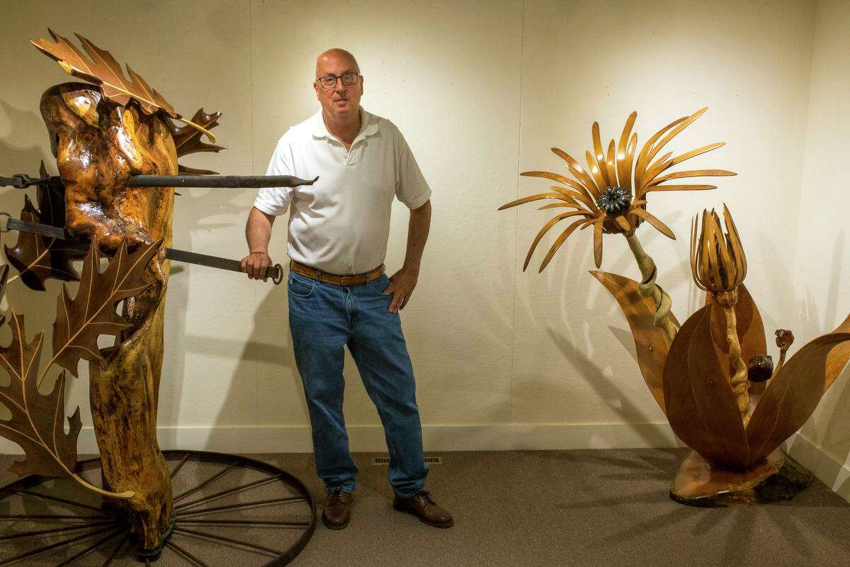 Terrence Tougas with two of his wood pieces from his KAA Solo Show.