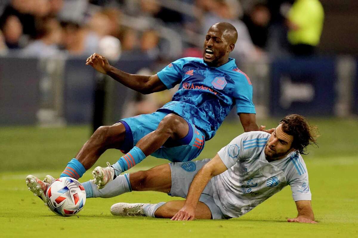 Sporting KC’s Graham Zusi tackles Dynamo midfielder Fafa Picault in Houston’s loss on Saturday.