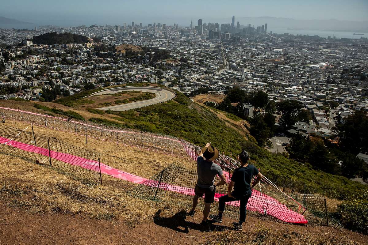 Mark Alexander (left) and Martin Hsu pause in front of the Pink Triangle Memorial on the slope of Twin Peaks on Sunday, their 14th anniversary.