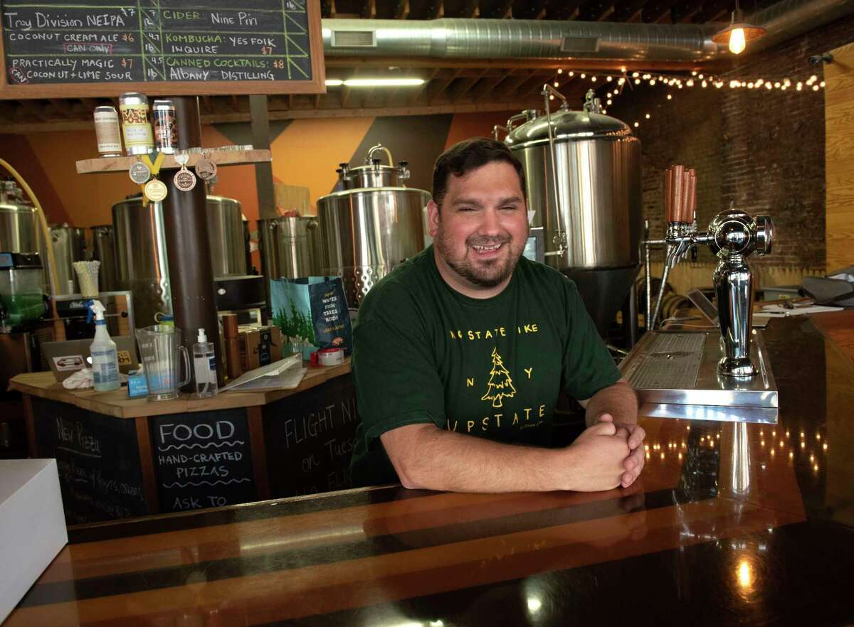 Sales director Greg Back stands behind the bar at Rare Form Brewing in Troy.