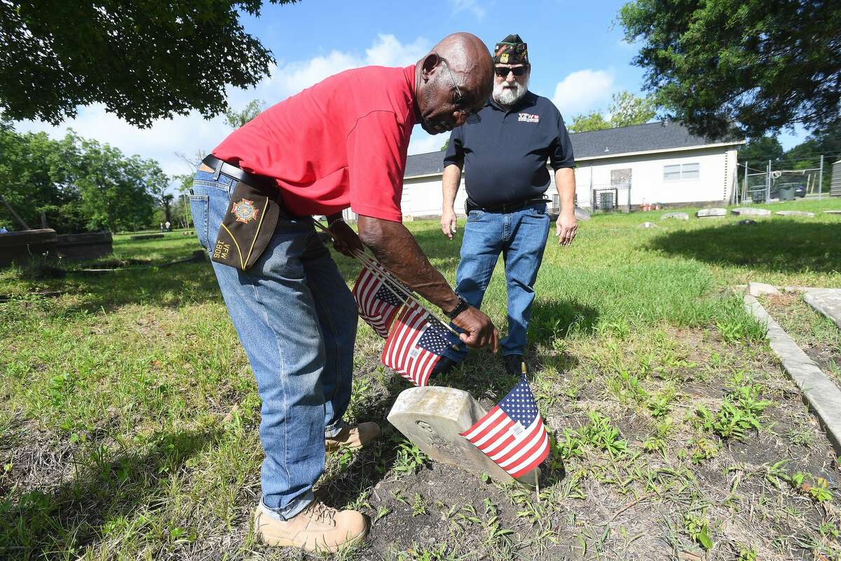 VFW Post 1806 Chaplain Tim Winberg looks on as commander Lewis Harris places a flag at a veteran's marker during a Memorial Day celebration honoring veterans buried in Evergreen Cemetery Monday. Photo made Monday, May 31, 2021 Kim Brent/The Enterprise