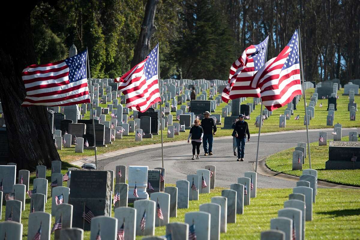 People walk through San Francisco National Cemetery in San Francisco, Calif. on Memorial Day, Monday, May 31, 2021.
