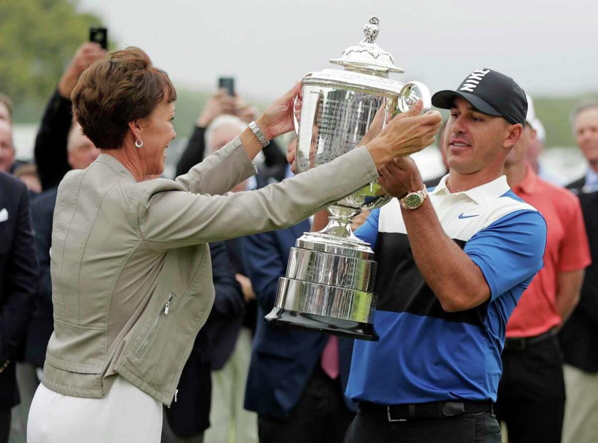 PGA president Suzy Whaley, left, hands Brooks Koepka the Wanamaker Trophy after he won the PGA Championship golf tournament, Sunday, May 19, 2019, at Bethpage Black in Farmingdale, N.Y. (AP Photo/Julio Cortez)