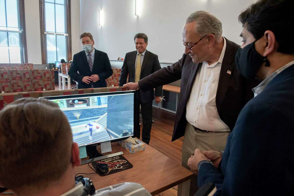 U.S. Senate Majority Leader Chuck Schumer, second from right, stops to view a game being developed by Velan Studios with co-founder Karthik Bala, right, during a visit to Velan Studios on June 1, 2021 in Troy, N.Y. The senator is now pushing for Microsoft to invest in the region after it acquired Activision Blizzard, the parent company of  Vicarious Visions, which has 200 employees in Colonie and was started by Bala and his brother, Guha Bala, in Troy in the 1990s. The Balas have since launched Velan Studios. (Lori Van Buren/Times Union)