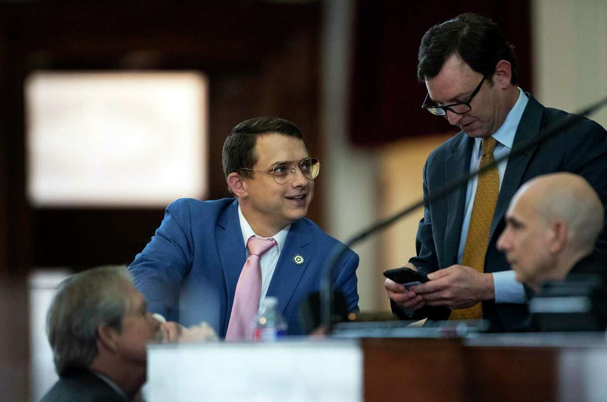 State Rep. Briscoe Cain, R - Deer Park, middle, and state Rep. Craig Goldman, R - Fort Worth, right, wait on the House floor for the start of the debate of Senate Bill 7, known as the Election Integrity Protection Act, at the Capitol on Sunday May 30, 2021, in Austin, Texas. (Jay Janner/Austin American-Statesman via AP)